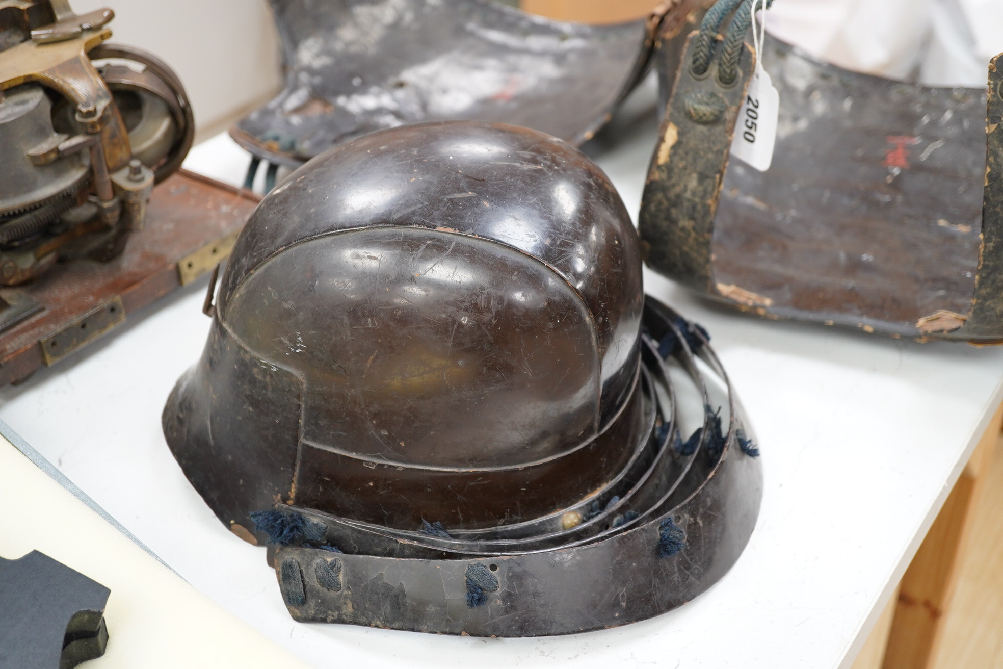 A Japanese armour, 19th century or earlier comprising; helmet Kabuto of five plates covered in black lacquer with 4-plate shikoro, also an iron lacquered mempo with three lames to throat and a do opening at side, embosse